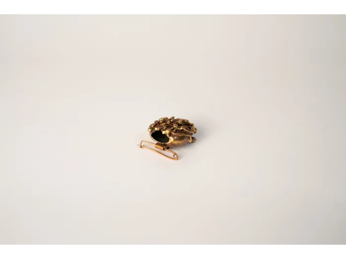 Stylization of a bronze vase in a brooch